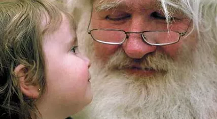 A little girl sitting on Santa's lap
