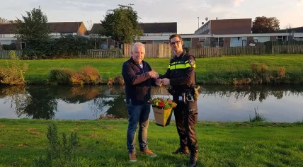 Cees van Loon gets flowers from the Den Bosch police after he saved a toddler from drowning, 19 Oct 2017