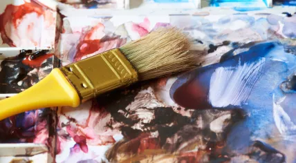Yellow paintbrush on a watercolor palette