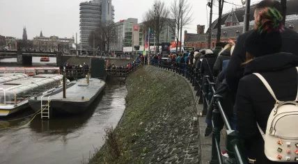 Tourists line up for canal boat tours in Amsterdam