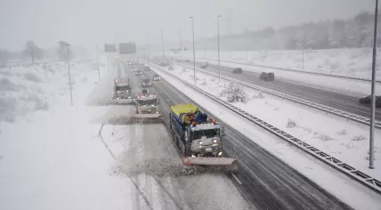 Rijkswaterstaat trucks working to clear snowy roads