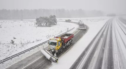 Rijkswaterstaat trucks working to clear snowy roads