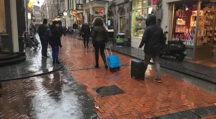 Pedestrians brave cold, wet weather in Amsterdam Centraal, 15 Jan 2018