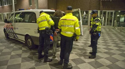 Arrested suspect loaded into a police van
