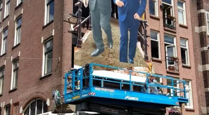 King Willem-Alexander and mayor Eberhard van der Laan on the facade of cafe Blaffende Vis in Amsterdam. King's Day, 27 April 2018