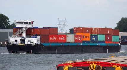 Ship transporting containers on the Maas river