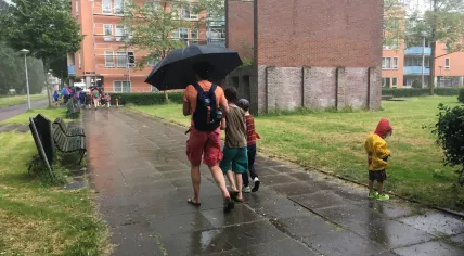 Parents walking with kids participating in the second night of the Avond Vierdaagse in Amsterdam Oost, despite the Code Orange storm warning, 29 May 2018