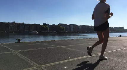 A jogger exercising along the Veemkade in Amsterdam on a warm summer's day, 29 June 2018