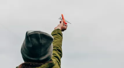 Child playing with toy airplane