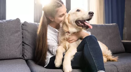 Woman cuddling a Golden Retriever