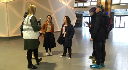 A Red Cross volunteer explaining a nationwide public transit strike to tourists at a largely deserted Amsterdam Central Station, 28 May 2019