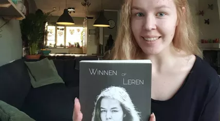 Noa Posthoven with her autobiography Winnen of Leren