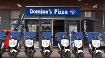 Delivery scooters in front of a Domino's Pizza in The Hague
