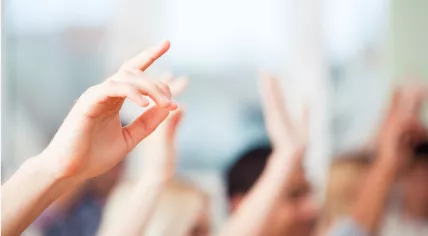 Kids raising their hands in class