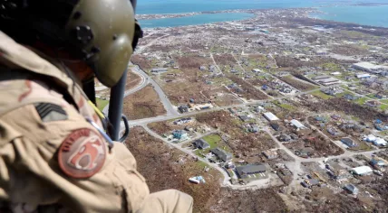 Dutch soldier surveying the Bahamas island of Abaco from a helicopter after Hurricane Dorian, Sept 2019