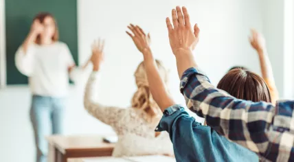 Pupils raising their hands in class