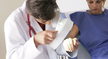 Dermatologist examining a woman's skin