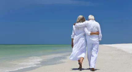 An older couple walking on the beach