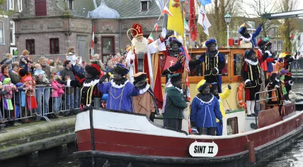 Sinterklaas and Zwarte Pieten arriving on their steamboat 