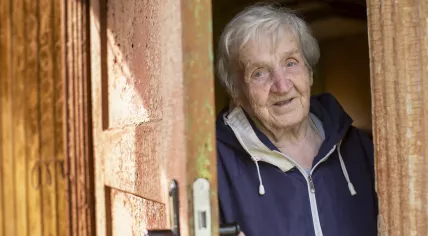 Elderly woman opening the door