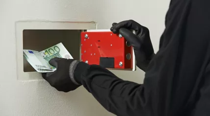 Thief stealing money from a safe