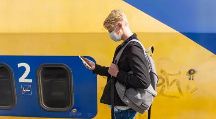 Student wearing a face mask next to a NS train during the summer of 2020