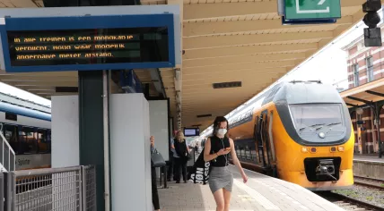 A woman wearing a face mask on a platform at the Hoorn train station. August 2020