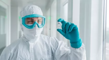 Undated photo of a CureVac employee with a vaccine vial