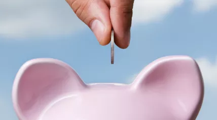 Person saving money in piggy bank