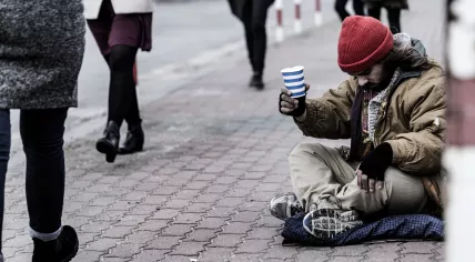 People walking past a begging man