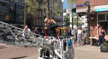 Singer Marcel Fokker wraps up his concert on a ladder truck for residents of De Gooyer in Amsterdam Oost. April 24, 2020