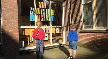 Covid-19: Kids at a closed school in Amsterdam Centrum. The sign in the window reads "We miss you". 20 April 2020