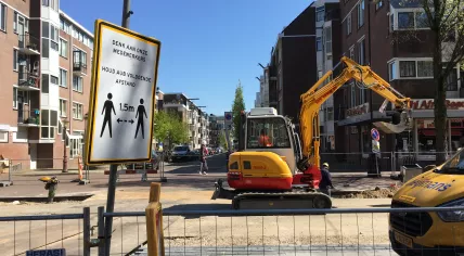 A sign telling people to keep their distance from workers on the Dapperstraat in Amsterdam Oost.