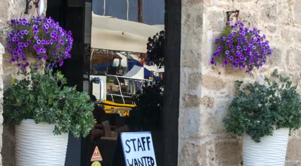'Staff wanted' sign in front of a cafe