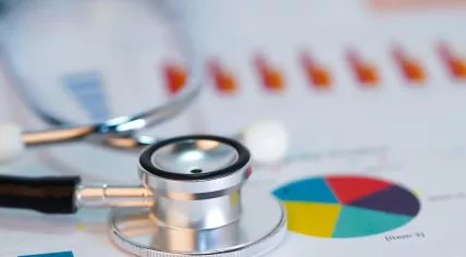 A stethoscope against a series of charts and graphs