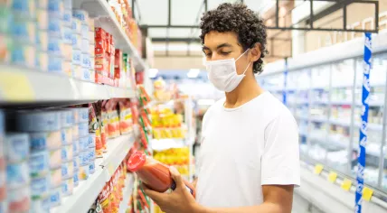 Young man wearing a face mask in a grocery store