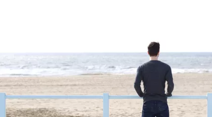 A man standing alone looking out on the Dutch coast
