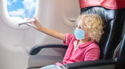 Child wearing a face mask on a plane