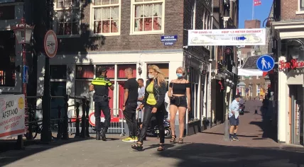 Police in Amsterdam discuss a mandatory face mask law with people on the Bet van Beerenbrug in the Red Light District. August 5, 2020