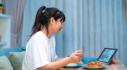 Woman eating dinner while on a video call