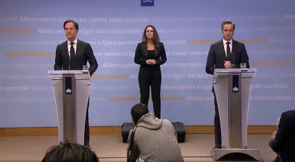 Mark Rutte and Hugo de Jonge, with interpreter Irma Sluis, at a press conference announcing a curfew and other coronavirus restrictions. 20 January 2021