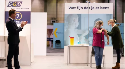 Hugo de Jonge looks on as nurse Sanna Elkadiri, 39, receives the first coronavirus vaccine in the Netherlands. 6 Jan. 2020