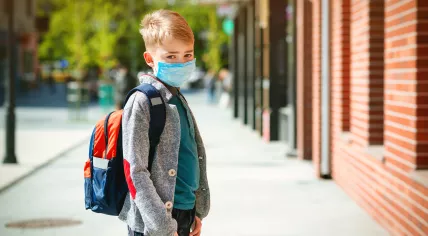 Child in a mask going to school