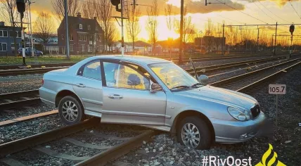 Minor parks car on train tracks 