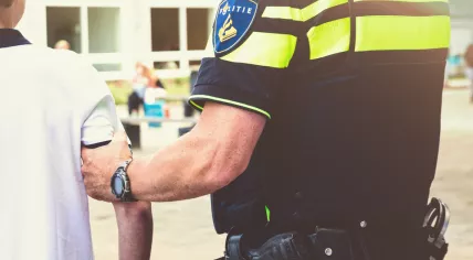 A Dutch police officer arresting a boy