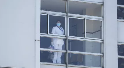 A healthworker looking through a window in Hospital during the coronavirus pandemic.