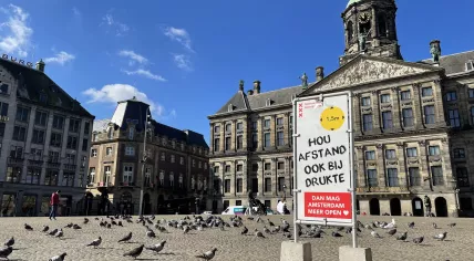 A sign promoting social distancing in front of the palace at Dam Square in Amsterdam. 19 March 2021.