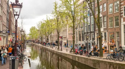 Tourists alongside a canal in Amsterdam.