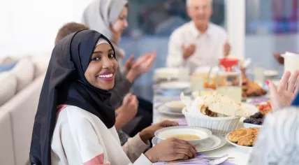 A Muslim woman eating with her family during Ramadan.