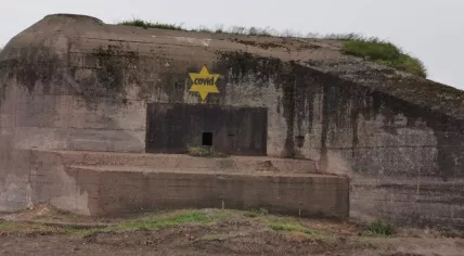 WW2 bunked in Koudekerke sprayed off with yellow Jewish stars carrying the text Covid.